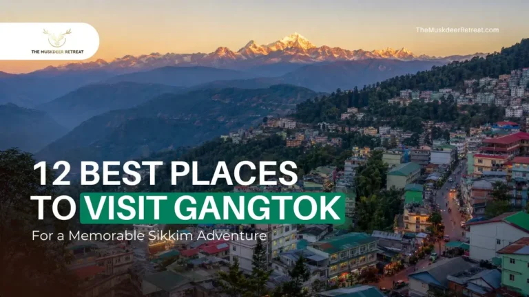 A scenic wide-angle view of Gangtok town nestled in the green hills of Sikkim at dawn, with the snow-capped peaks of Mount Kanchenjunga visible in the background.